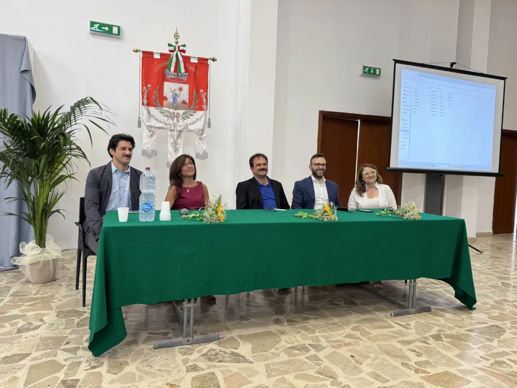 Protagonisti seduti al tavolo dell'evento con bandiera del comune di Santa Ninfa