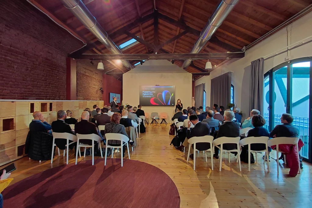 audience sitting on chairs while a woman is speaking on stage