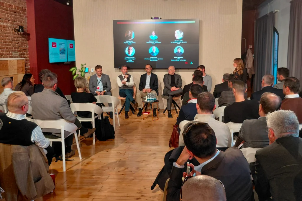 panel discussion with 5 men and a woman. audience listening