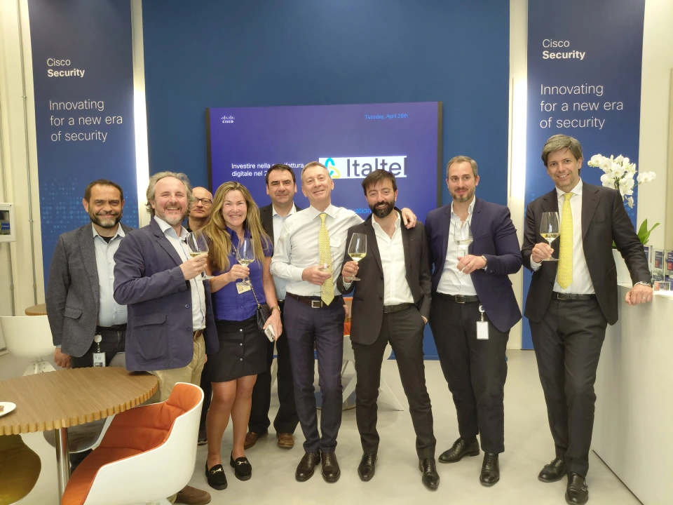 A group of people standing smiling and cheering with a glass in their hands